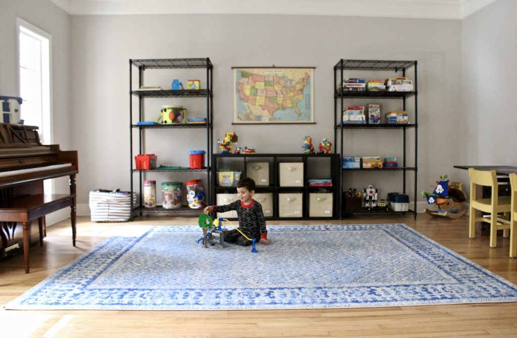Playroom with blue carpet and black shelves