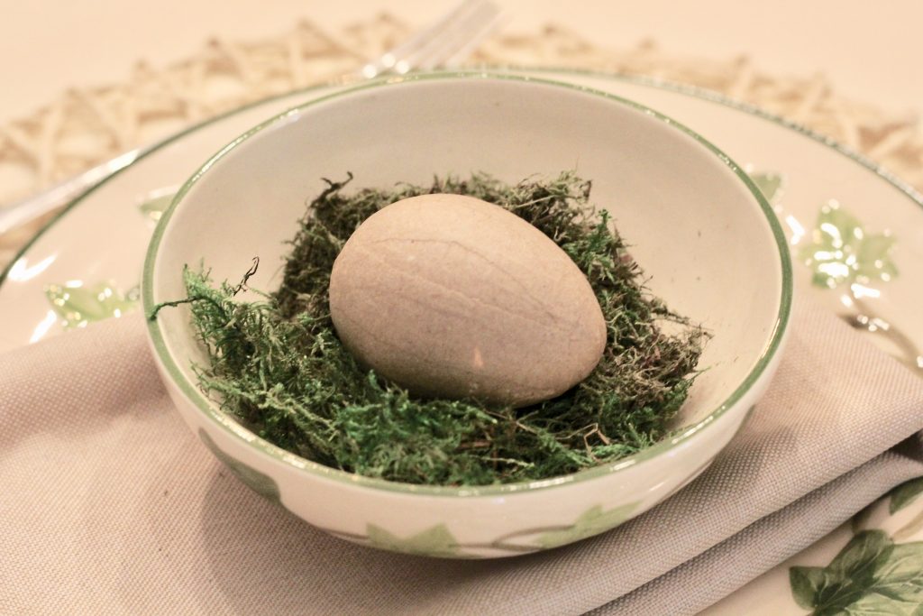brown paper mâché egg in bowl with moss