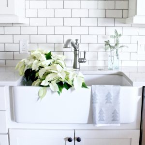 White farmhouse sink with pine tree clippings and white poinsettias | www.ourhammockhouse.com 