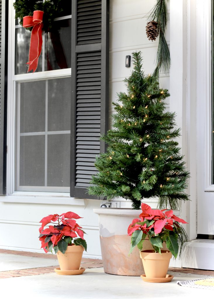 Christmas front porch with small Christmas tree and red poinsettias in terra cotta pots |#frontporch #christmasdecor #poinsettia