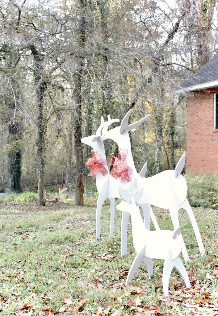 Handmade wooden deer for front yard painted white with red bows | #christmasdecor 