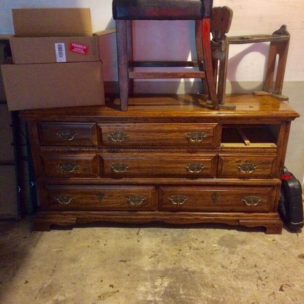 Dated old brown dresser with tacky drawer pulls