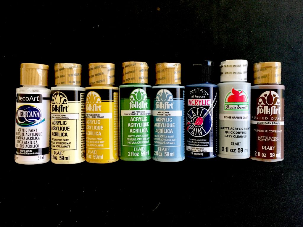 Acrylic craft paints in white, yellow, green, blue, gray, and brown 