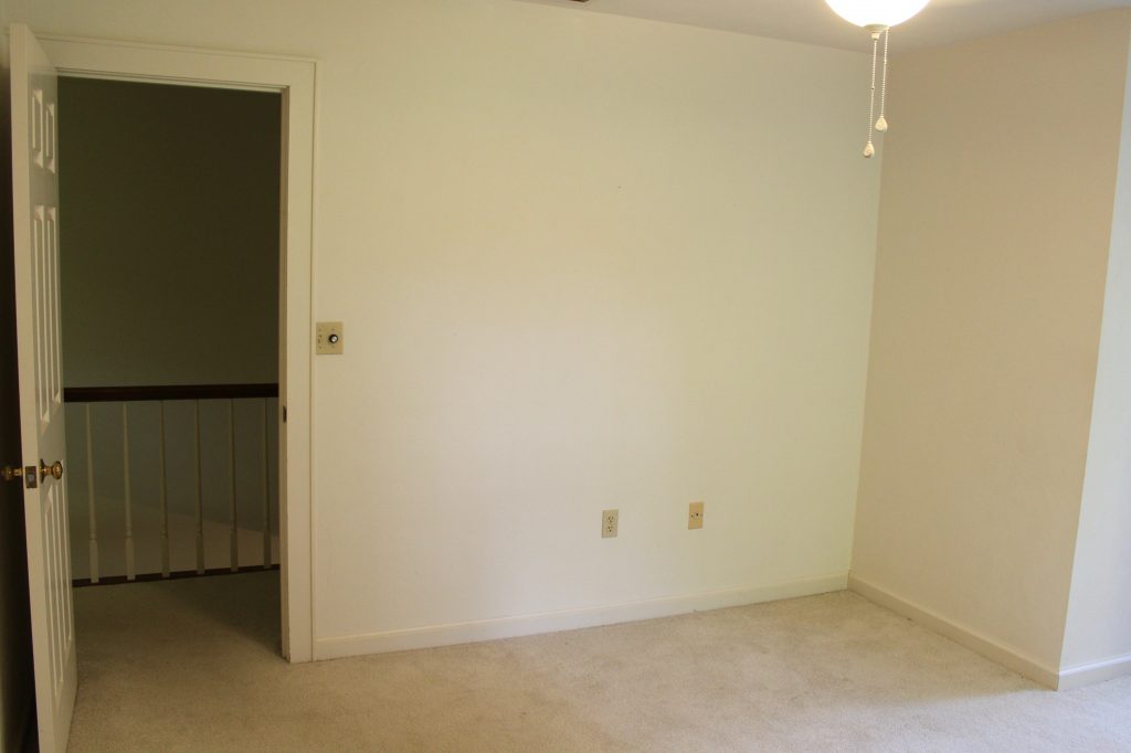 Before image of boys' bedroom with white walls and dirty white carpet