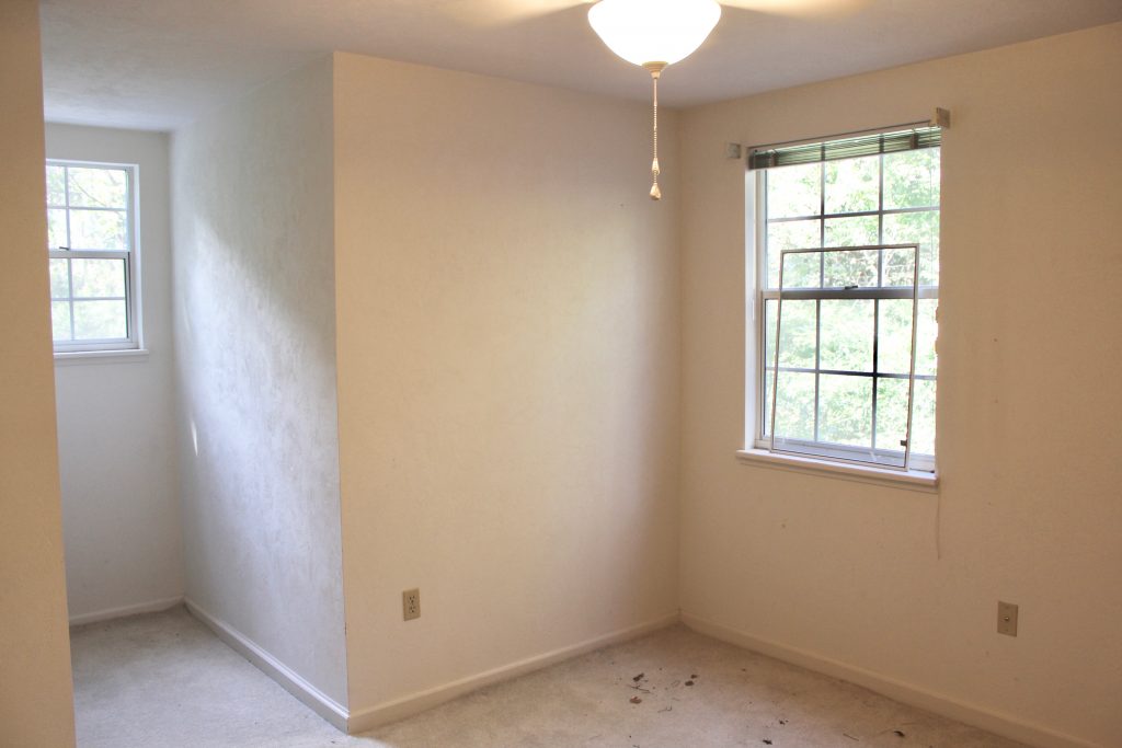Before image of boys' bedroom with white walls and dirty white carpet