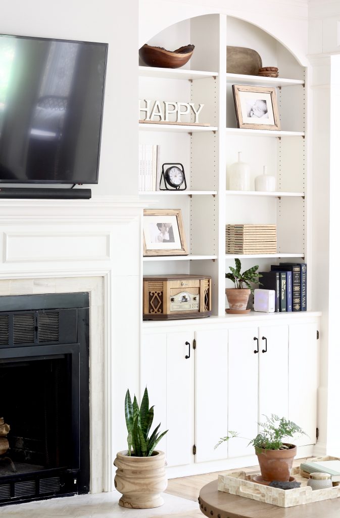 Tips on how to decorate and style built in shelves in your living room around the fireplace using neutral decor | www.ourhammockhouse.com | #builtinshelves #livingroom #fireplace #neutraldecor