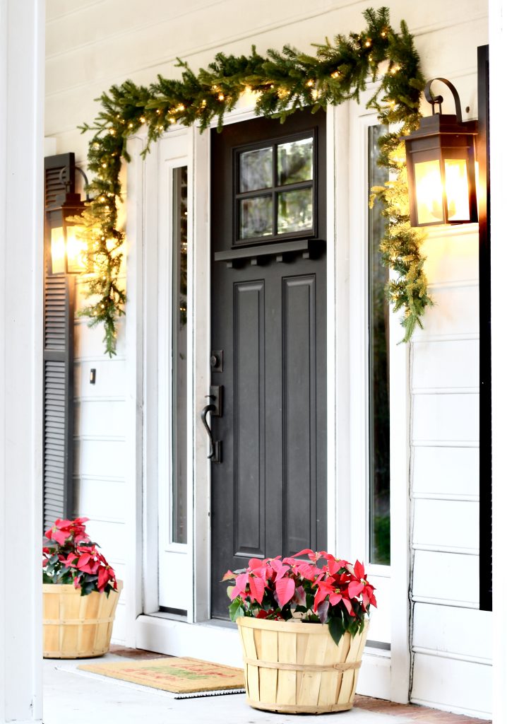 Christmas Home Tour 2019 | Modern Farmhouse Christmas Front Porch with black front door, lit garland, and red poinsettias | www.ourhammockhouse.com | #christmasfrontporch 