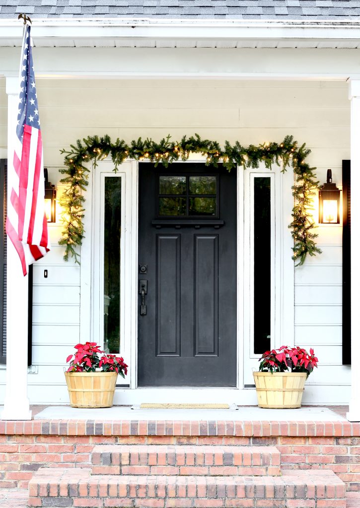 Christmas Home Tour 2019 | Modern Farmhouse Christmas Front Porch with black front door, lit garland, and red poinsettias | www.ourhammockhouse.com | #christmasfrontporch 