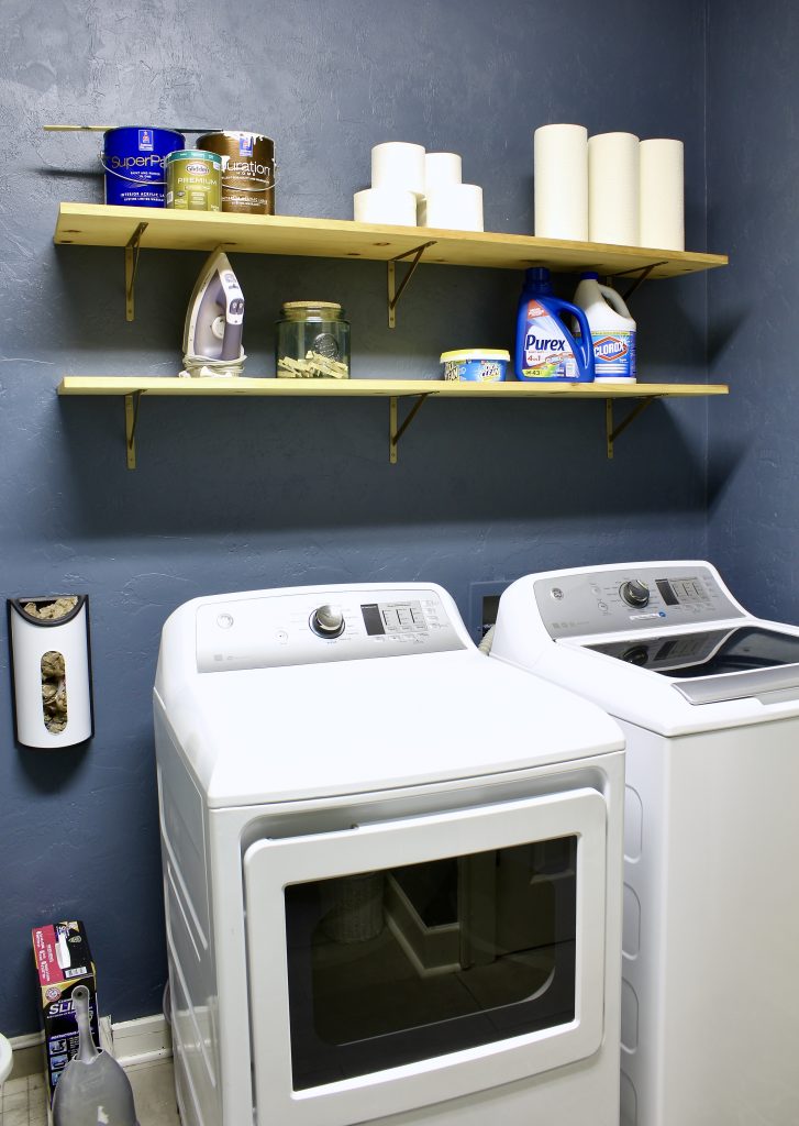 Laundry room makeover with navy blue walls and open shelving| www.ourhammockhouse.com | #laundryroom #laundryroommakeover
